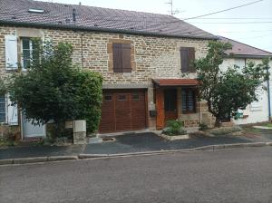 a brick house with a wooden garage on a street at L'annexe in Chalindrey