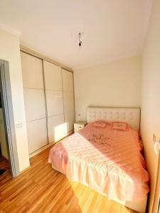1 dormitorio con 1 cama grande y suelo de madera en Lake majesty, en Shkodër