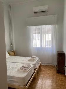 um quarto com uma cama e uma janela com toalhas em Graffiti Ground Floor em Atenas