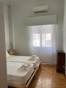 a bedroom with a bed and a window with towels on it at Graffiti Ground Floor in Athens