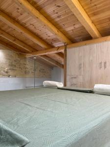 Habitación con cama y techo de madera. en Casa di Fragkiskos. Ένα σπίτι μέσα στη φύση., en Kondomárion