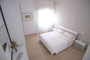 - une chambre blanche avec un lit blanc et une fenêtre dans l'établissement Casa Vacanza MaGia Pineto, à Pineto