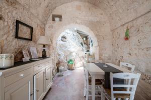 een keuken met een tafel en een stenen muur bij La Lamia 1864 by Rentbeat in Ostuni