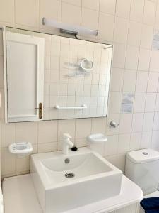 a bathroom with a sink and a mirror and a toilet at Casa Gato in Corralejo