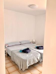 two beds in a white room with towels on them at Casa Gato in Corralejo