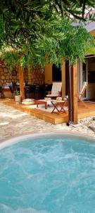 a swimming pool in front of a house with a patio at Salt & Stone Villa in Pag