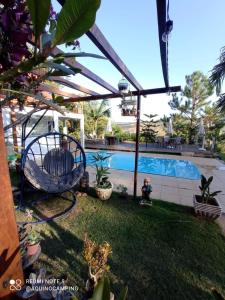 una piscina con una silla en un patio en Aqui no Camping, en Brumadinho