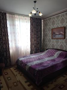 a bedroom with a purple bed and a window at Apartament Anastasia.Plaja Modern in Constanţa