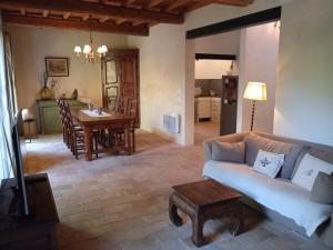 ein Wohnzimmer mit einem Sofa und einem Tisch in der Unterkunft Mazet Des Artistes in Mouriès
