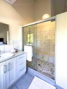 W łazience znajduje się szklana kabina prysznicowa i umywalka. w obiekcie DE WET 5 FRANSCHHOEK w mieście Franschhoek