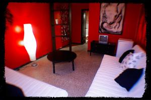 1 dormitorio rojo con 1 cama y 1 silla en Pensión El Alamo, en Lepe