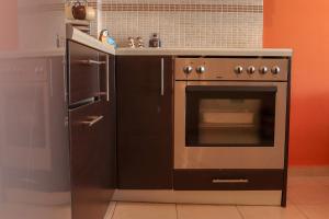 La cuisine est équipée d'une cuisinière, d'un évier et d'un réfrigérateur. dans l'établissement Sunshine Apartments #02, à Thessalonique
