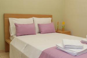 - une chambre avec un lit et des oreillers violets dans l'établissement Sunshine Apartments #02, à Thessalonique