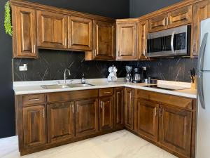una cocina con armarios de madera y electrodomésticos de acero inoxidable en Ancla Suite 8 - 2 Bedroom Urban Hotel, en Puerto Peñasco
