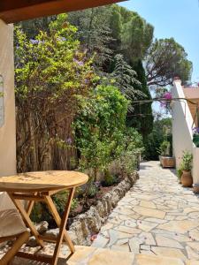 a patio with a wooden table and a stone walkway at PROCHE CONGRES PLAGES CLIM in Cannes