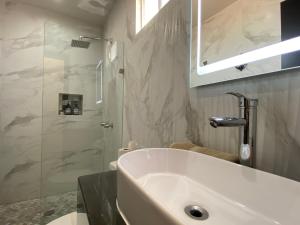 a bathroom with a large white tub and a shower at Ancla Suite 8 - 2 Bedroom Urban Hotel in Puerto Peñasco