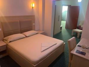 una camera da letto con un letto con un foglio sopra di Kriva Resort a Elbasan