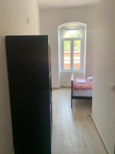 a black refrigerator in a room with a window at Rajski Horizonti - Rooms Ram I in Ram
