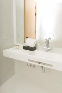 La salle de bains blanche est pourvue d'un lavabo et d'un miroir. dans l'établissement QUINTA ALTO DO RIO, à Cinfães