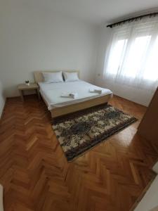 a bedroom with a bed and a wooden floor at Centar Apartment in Gevgelija