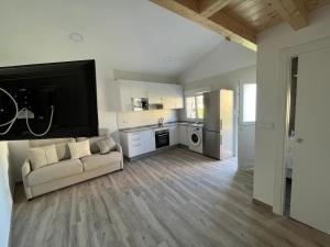 a living room with a couch and a kitchen at A Casa de Fóra in Muros
