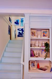 a staircase leading up to a room with blue and white shelves at The Art House By The Sea in Plomarion