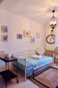 a bedroom with a bed and a table and a chandelier at The Art House By The Sea in Plomarion