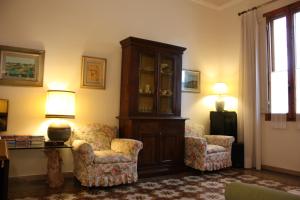 a living room with two chairs and a cabinet at Rooms by Anna in Florence