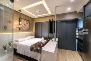 1 dormitorio con 1 cama y pared de cristal en VU3 - Estilo e Conforto: Studio de Luxo Próx. ao Allianz Parque, en São Paulo