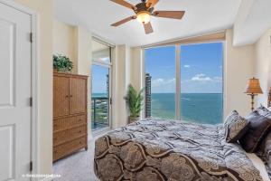 a bedroom with a bed and a large window at Amazing WATERVIEW in every room, PORTOFINO Island Resort condo in Pensacola Beach