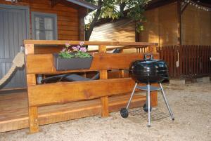 a grill and a pot of flowers on a fence at Chatka Daisy A,B in Pakoštane