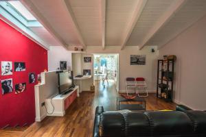 ein Wohnzimmer mit einem Sofa und einer roten Wand in der Unterkunft Casa Tommasini in Capaccio-Paestum