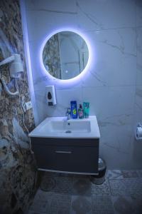La salle de bains est pourvue d'un lavabo et d'un miroir rond. dans l'établissement Vila Visi Hotel, à Korçë