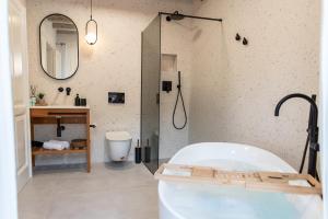 a bathroom with a tub and a sink and a mirror at Shee-Lu Suites in Dubrovnik