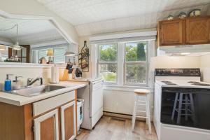 a kitchen with a sink and a stove at Boyne City Cottage Walk to Downtown and Lake! in Boyne City +18 photos