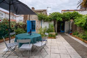 a table and chairs with an umbrella on a patio at maison tartifume in Pornic