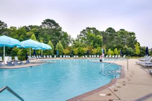 a large swimming pool with chairs and umbrellas at 3 Mi to Bethany Beach Ocean View Home with Patio in Clarksville
