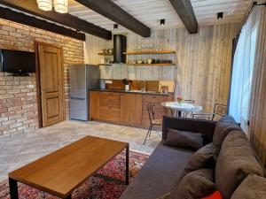 a living room with a couch and a table and a kitchen at Anykščiai MĖNULIO AKMUO in Stariai