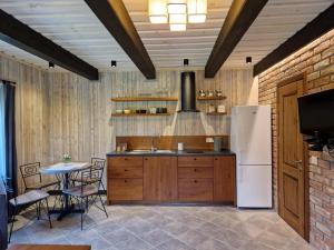 a kitchen with a white refrigerator and a table at Anykščiai MĖNULIO AKMUO 