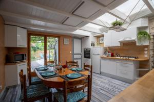 a kitchen and dining room with a table and chairs at maison tartifume in Pornic