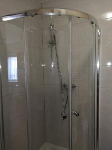 um chuveiro com uma porta de vidro na casa de banho em Mielno, Spokojna 2A - blisko plaży em Mielno