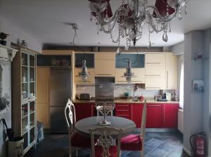 a kitchen with red cabinets and a table and chairs at Apartamento San Quirce - céntrico y reformado- wifi y netflix in Valladolid