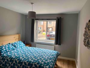 a bedroom with a bed and a window at Spacious Ground Floor 2 Bed by Lains Lettings in Aberdeen