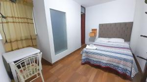 a small bedroom with a bed and a chair at HOSTAL MISTER SOSA in Ica