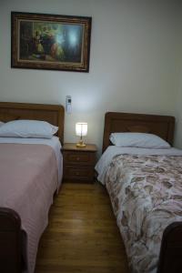 - 2 lits dans une chambre avec une photo sur le mur dans l'établissement Vila Visi Hotel, à Korçë
