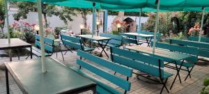 a row of tables and chairs with an umbrella at Casa Asteria - Mamaia Nord in Mamaia Sat/Năvodari
