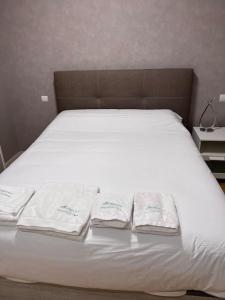 a white bed with three folded towels on it at Relájate después de patear Madrid in Madrid