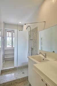 ein weißes Bad mit einem Waschbecken und einer Dusche in der Unterkunft appartamento incantevole sui navigli in Corsico