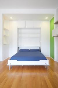 Schlafzimmer mit einem Bett mit blauer Bettwäsche und grünen Wänden in der Unterkunft appartamento incantevole sui navigli in Corsico