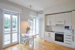 a kitchen with white cabinets and a table at appartamento incantevole sui navigli in Corsico